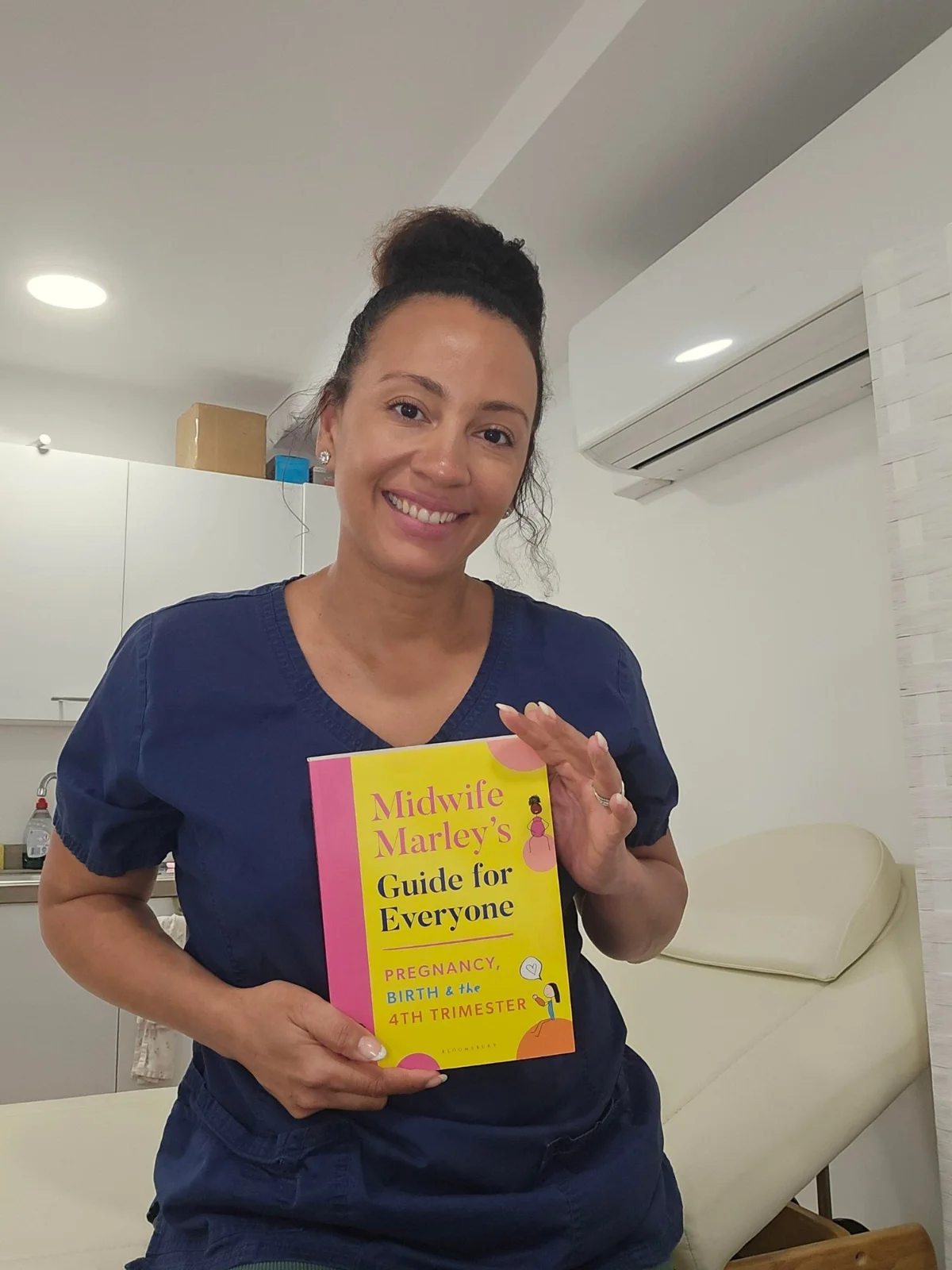 Marley Henry holding Midwife Marley's Guide for Everyone
